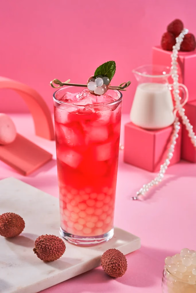 The Boba Co yemek fotoğrafı, lychee bubble tea, taze lychee meyveleri ve süt sürahisi ile pembe stüdyo kompozisyonu, Ankara yemek fotoğrafçısı Şems Erik
