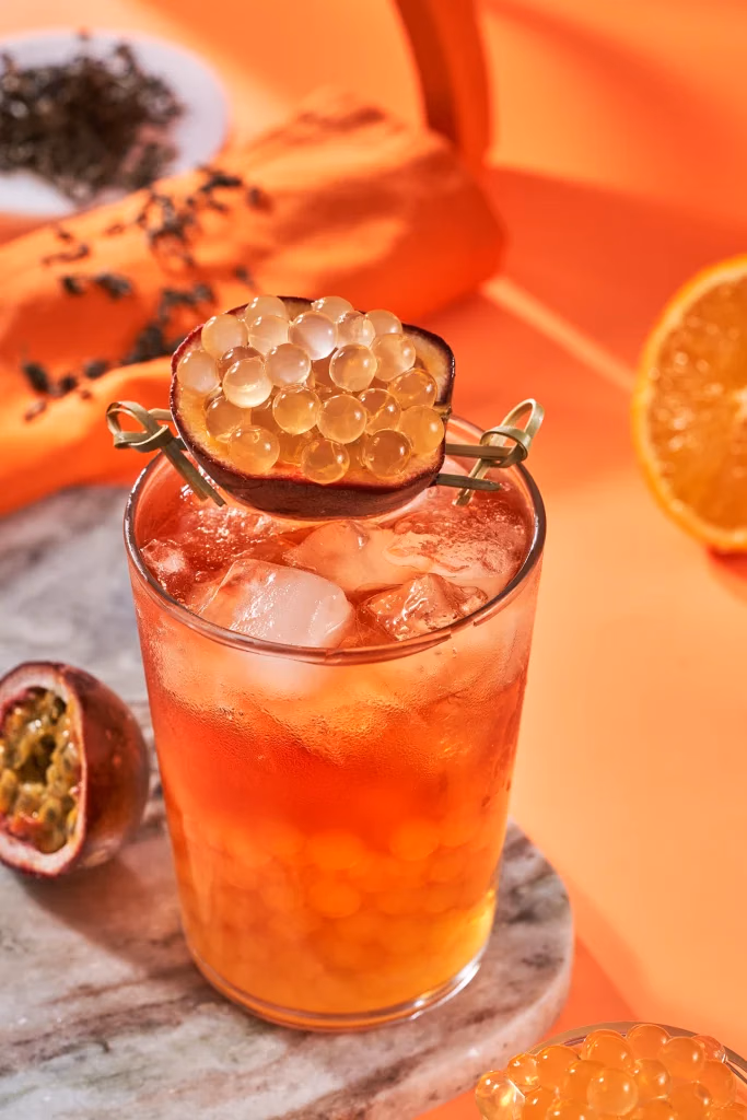 The Boba Co yemek fotoğrafı, passion fruit soğuk çay, çarkıfelek meyvesi ve inci taneleri yakın çekim, turuncu fon üzerinde, Ankara yemek fotoğrafçısı Şems Erik