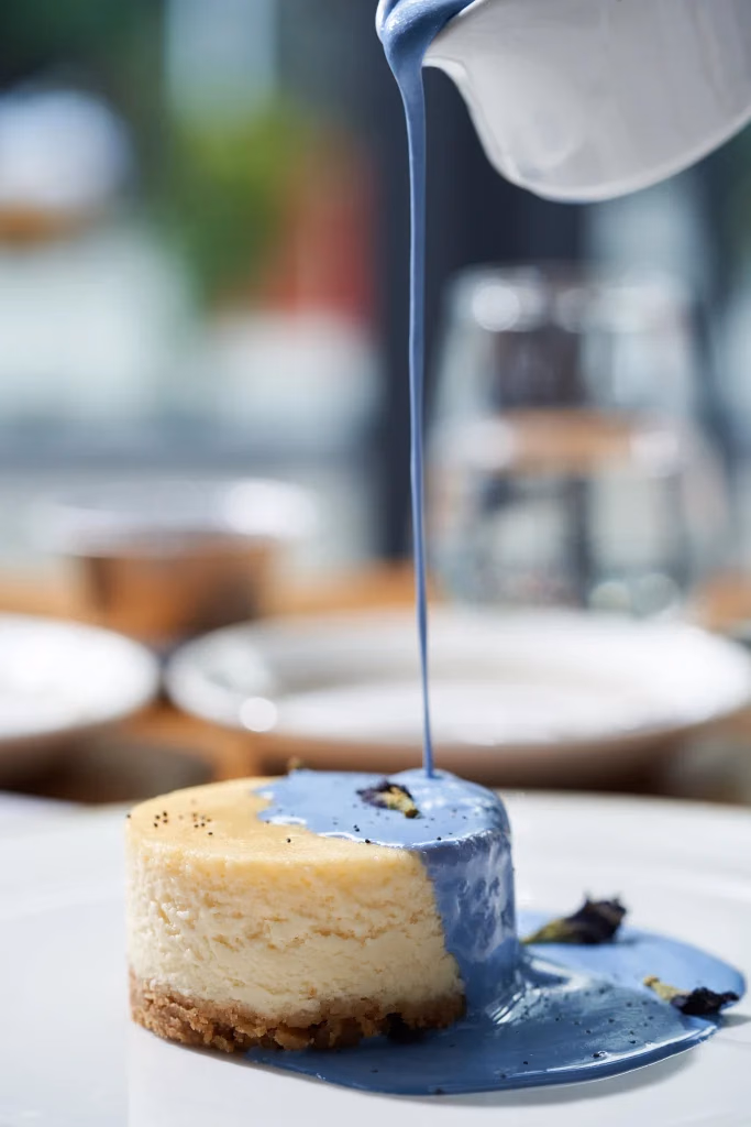 Levante Culinary restoran yemek fotoğrafı, cheesecake üzerine mavi sos dökümü, hareket anı, bulanık arka plan, Ankara yemek fotoğrafçısı Şems Erik