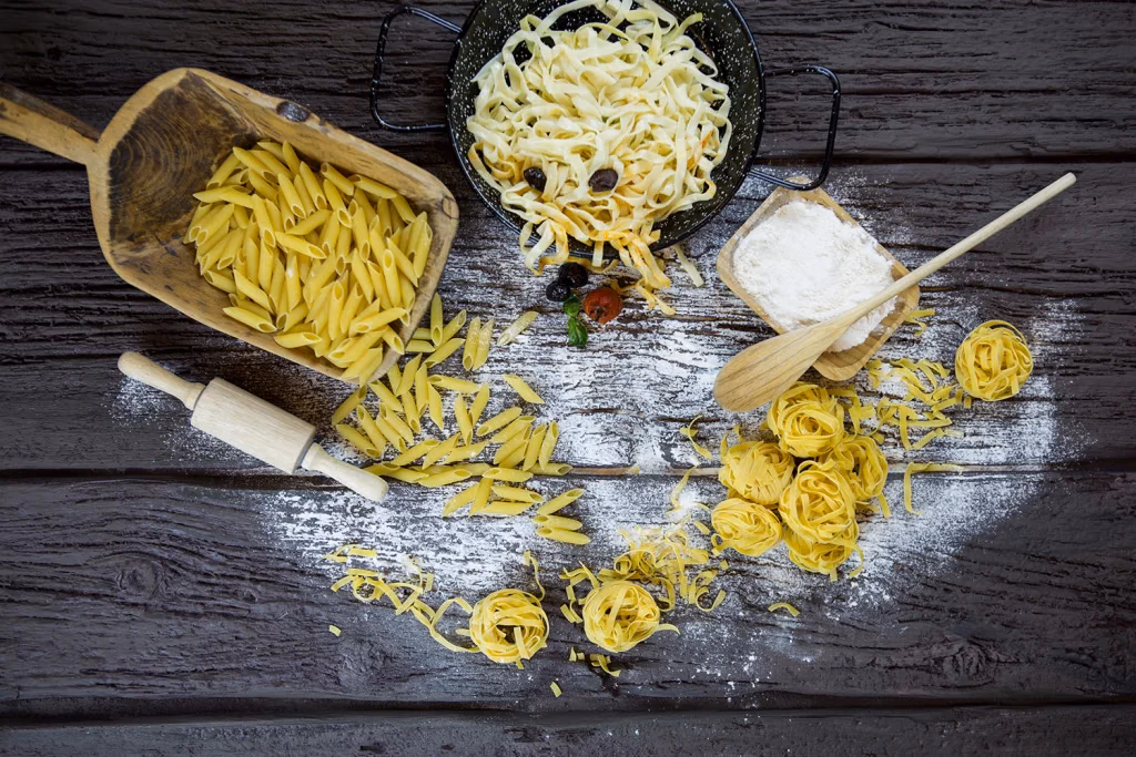 Liva gastronomi fotoğrafı, çiğ makarna çeşitleri ve un serpilmiş ahşap zemin, mutfak hazırlık sahnesi, Ankara yemek fotoğrafçısı Şems Erik