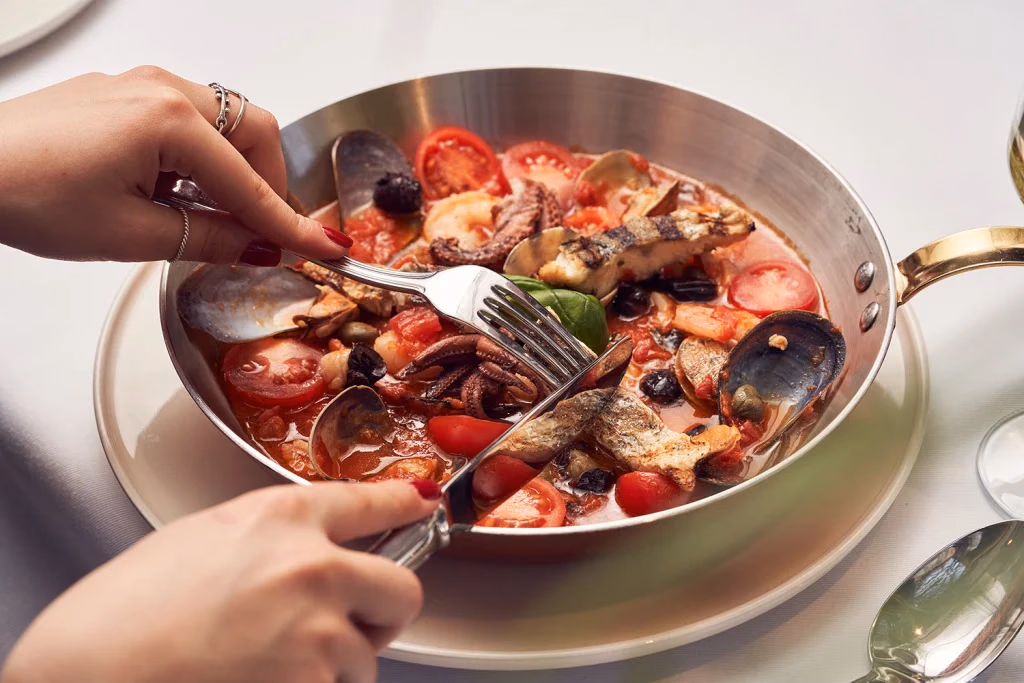 Vento Italiano restoran yemek fotoğrafı, tavada deniz mahsulleri yemeğinden servis alınan an, yandan açı, Ankara yemek fotoğrafçısı Şems Erik